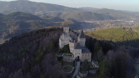 Orbiting-Drone-Shot-of-a-Castle-with-Mountains-and-a-Valley-in-the-Background,-4k-UHD