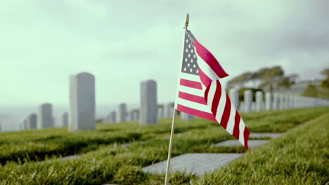 Closeup-of-American-Flag-put-in-the-ground-at-a-military-cemetery-in-San-Diego,-blowing-in-the-wind