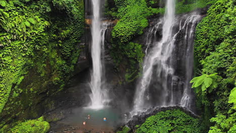 Tourists-taking-pictures-at-the-base-of-Sekumpul-Waterfall,-Bali