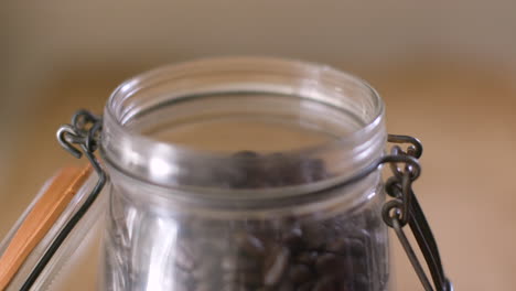 Close-Up-of-Pouring-Coffee-Beans-into-Mason-Jar-with-Lid