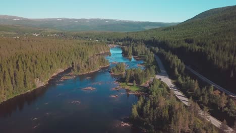 Crane-up-drone-shot-over-a-river-in-a-forest-in-mid-Norway