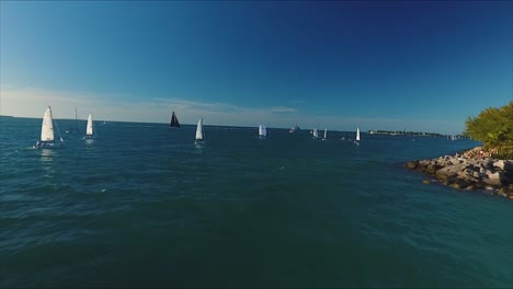Sailboats-race-as-the-camera-zooms-out-over-the-coast-of-Key-West,-FL----in-crisp-4K