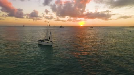 Sailboat-floats-as-the-sun-sets-while-a-drone-orbit's-around-the-boat-in-crisp-4K-resolution