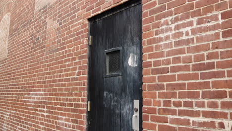 Black-Wooden-Door-in-Brick-Alley---Closeup