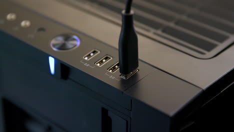 Man-Plugs-Multiple-USB-Cables-into-Desktop-Computer