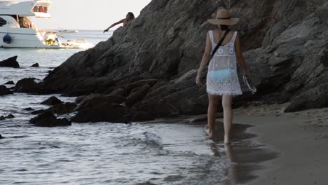 Mujer-Joven-Caminando-Por-La-Playa-Pensando-Y-Jugando-Con-Agua