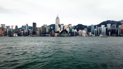 Hyperlapse-of-Hong-Kong-skyline-with-boats-passing,-moving-from-left-to-right