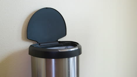 Man-Throws-Away-Yellow-Package-in-Motion-Sensing-Touchless-Trash-Can---Medium-Side