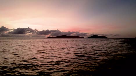 Luftaufnahme-Des-Sonnenuntergangs,-Der-über-Dem-Meer-Mit-Fernen-Inseln-Und-Wolken-Schimmert