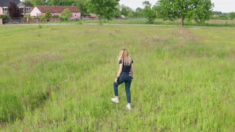 Filming-young-woman-how-she-is-picking-the-flowers-in-the-agricultural-field