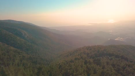 High-altitude-drone-shot-over-a-mountain-next-to-Athens,-Greece-on-a-summer-evening-during-golden-hour