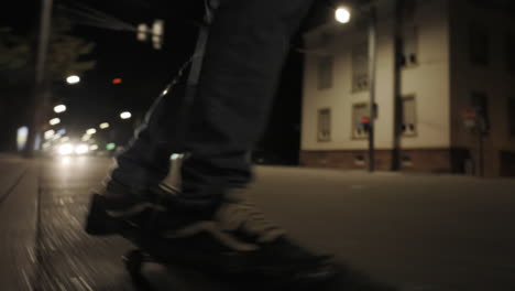 Skateboarding-trough-city-at-night,-closeup