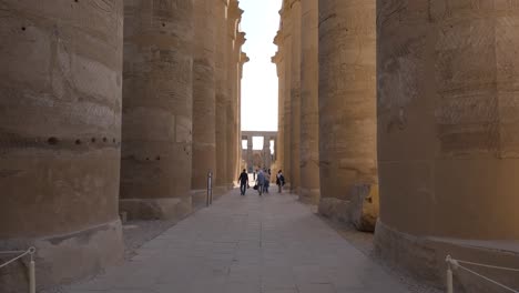Hand-held-shot-of-tourists-exploring-the-Luxor-Temple-and-its-pillars