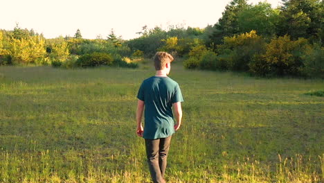 Teenage-boy-being-oblivious-to-the-beauty-of-nature-around-him,-walking-and-looking-at-his-smart-phone