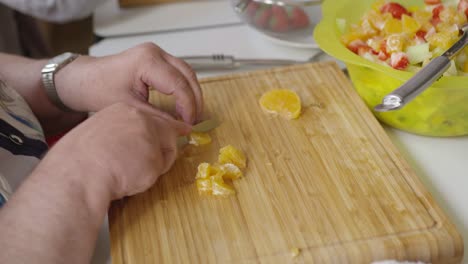 old-woman-cutting-fruit-for-fruit-salad