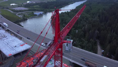 Crane-by-busy-highway-bridge-construction-zone-from-above