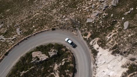 Vehicle-driving-around-the-offroad-corner-on-a-mountain-pass