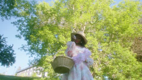 Black-Woman-walking-in-the-park-in-dress-with-basket-low-angle