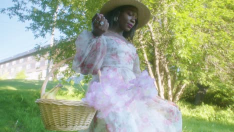 Black-Woman-walking-in-the-park-in-dress-with-basket-low-angle-circling