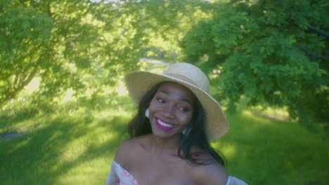 Black-Woman-on-picnic-in-park-looking-up-eye-contact-smiling