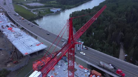 Crane-by-busy-highway-bridge-construction-zone-trucking