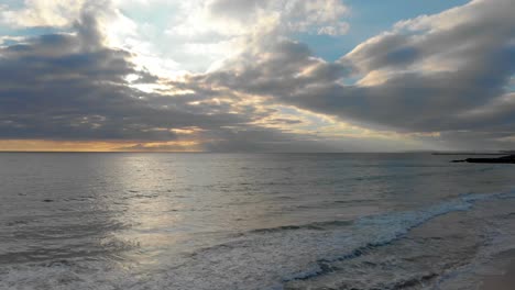 Sonnenuntergang-Mit-Einem-Bewölkten-Himmel-Und-Einem-Ruhigen-Ozeanufer