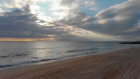 Sonnenuntergang-Mit-Bewölktem-Himmel-Und-Wellen,-Die-An-Einem-Strand-In-Portugal-Zusammenbrechen