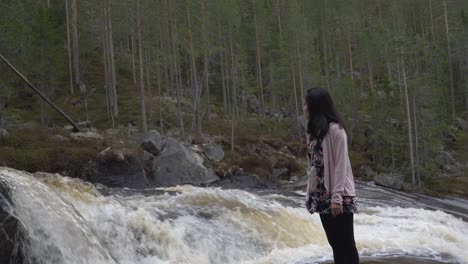 Girl-stands-beside-a-flowing-river