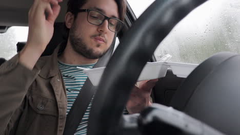 Young-Driver-Eats-Take-Away-Food-In-His-Car---Rainy-Day