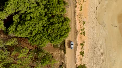 Car-going-throught-sandy-trail-by-a-beach-in-Algarve