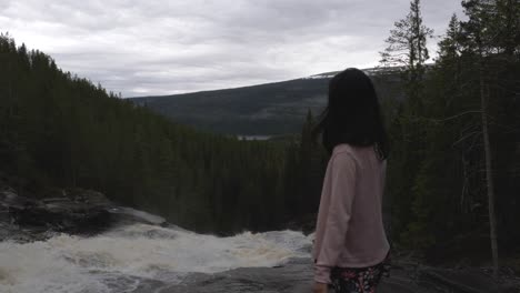 Mädchen,-Das-Einen-Wasserfall-Im-Wald-Betrachtet