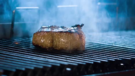 Großes-Steak-Wird-Gegrillt,-Es-Gibt-Rauch-Von-Den-Kohlen-Zum-Fleisch,-Seitenansicht,-Nahaufnahme-4kSteaksteak-Mit-Einer-Sehr-Leckeren-Aussicht-4k