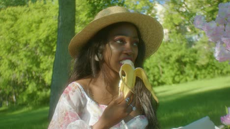 Mujer-Negra-Tranquilamente-Comiendo-Plátano-En-El-Parque-Dolly-En-Primer-Plano