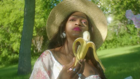 Black-Woman-calmly-eating-banana-in-park-close-up-pan