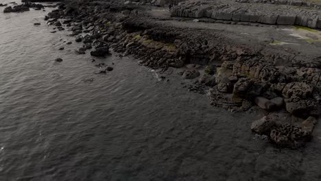 Drone-pan-showing-rocks-on-the-beach-near-the-Atlantic-Ocean-above-the-port-of-Doolin-by-the-Wild-Atlantic-Way-in-Doolin,-Co