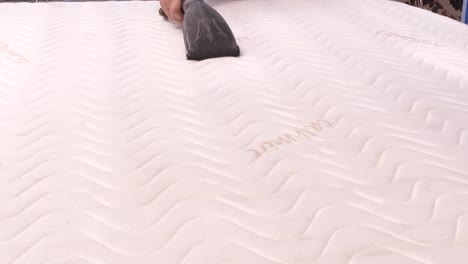 Vacuuming-mattress-with-professional-cleaner,-close-up