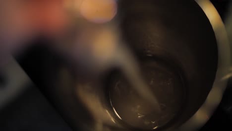 Pouring-liquor-into-stainless-steel-shaker-to-prepare-alcohol-cocktail,-close-up