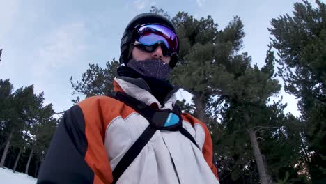 Selfie-video-of-young-man-skier-with-ski-goggles-going-down-the-slope-on-the-mountain