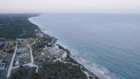 Rotierende-Drohnenaufnahme-Aus-Der-Luft-Der-Maya-Ruinen-Am-Strand-Von-Tulum-Mit-Herrlichem-Blick-Auf-Das-Meer-Und-Die-Landschaft-Mit-Bäumen-Und-Felsen-4K-Aufnahmen