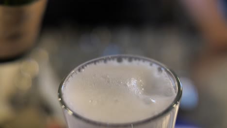 Bartender-pouring-champagne-to-cocktail-to-glass,-close-up