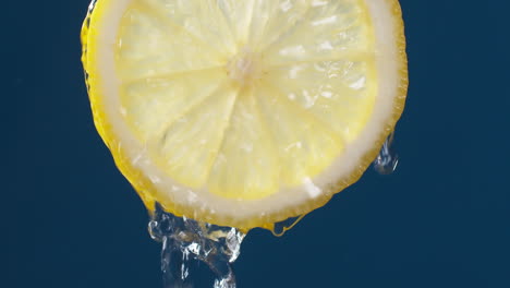 Makroaufnahme-In-Zeitlupe-Von-Fließendem-Wasser-Aus-Zitronenscheibe-Auf-Blauschwarzem-Hintergrund