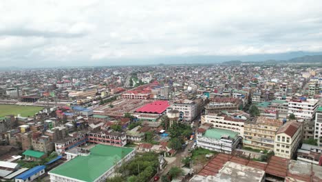 Aerial-Drone-Shot-of-Market-Surrounded-By-Buildings,-Bridge,-And-River-In-Imphal,-India