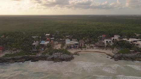 drone-shot-of-the-sunset-of-a-paradisiacal-beach-in-TULUM,-approaching-a-beach-club