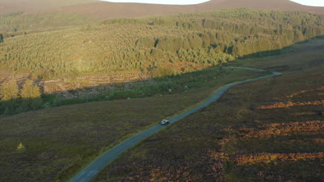 Aerial-view,-follow-shot,-4K,-drone-footage-following-a-car-driving-on-a-mountain-road