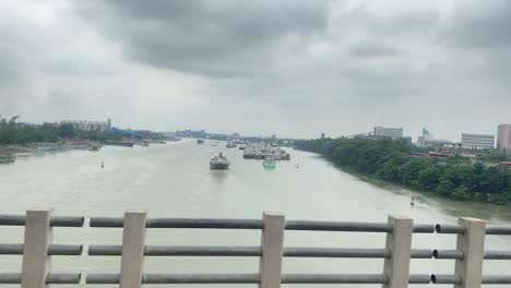 Fahren-Auf-Brücke-In-Sylhet-über-Surma-Fluss-Mit-Hafen-In-Der-Ferne,-Seitenansicht