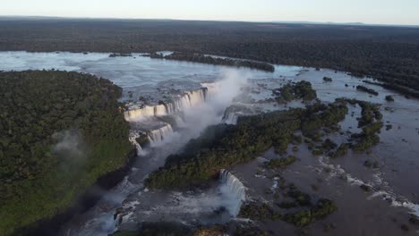Vogelperspektive-Auf-Die-Wasserfälle-Von-Iguazu-Nahe-Der-Argentinisch-brasilianischen-Grenze-Bei-Sonnenuntergang-Mit-Dem-Amazonas-Regenwald-Im-Hintergrund