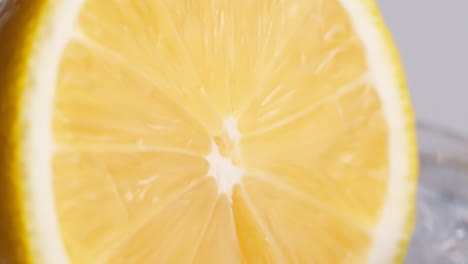 Slow-Motion-Macro-Shot-of-Flowing-Water-from-Lemon-Slice-on-white-Background