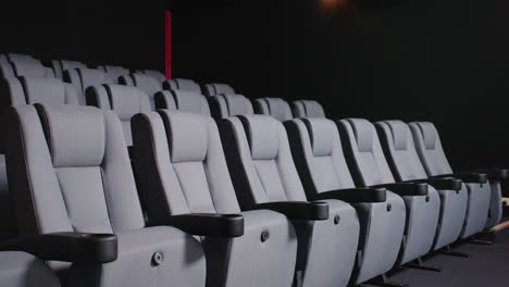 Dramatic-Lit-Modern-Cinema-Seating-With-Armrest-In-Dark-Movie-Theatre,-4K