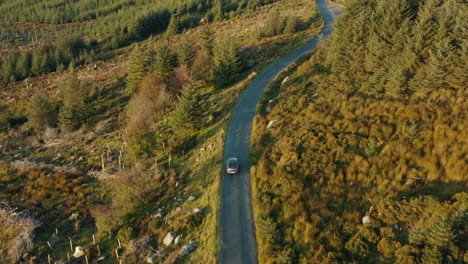 Aerial-footage,-following-a-car-on-a-mountain-pass-through-a-national-park