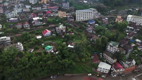 Aerial-drone-shot-of-houses-and-buildings-located-on-hills-in-Kohima-Nagaland,-India